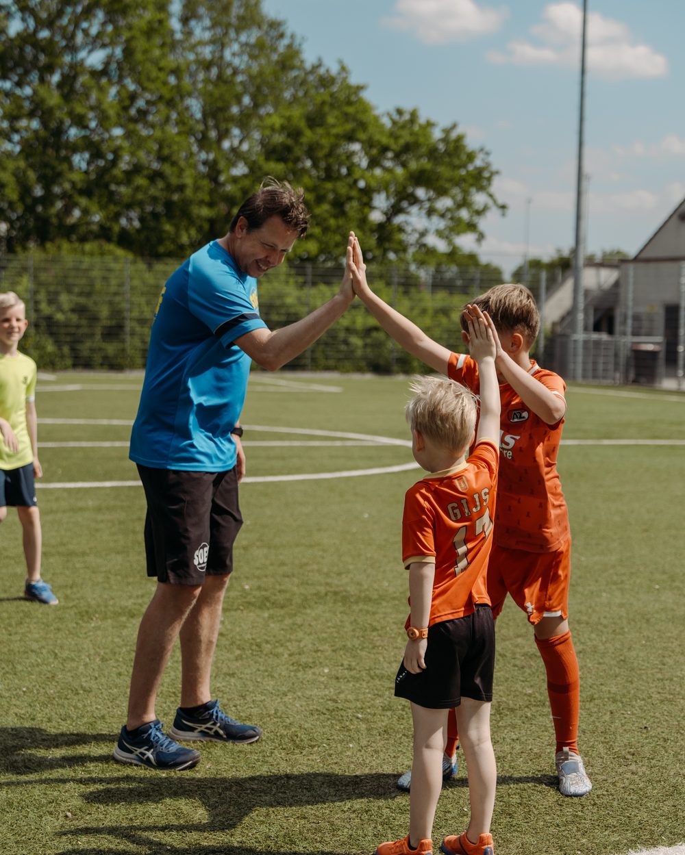 SOEF-begeleider geeft een high five aan een kind
