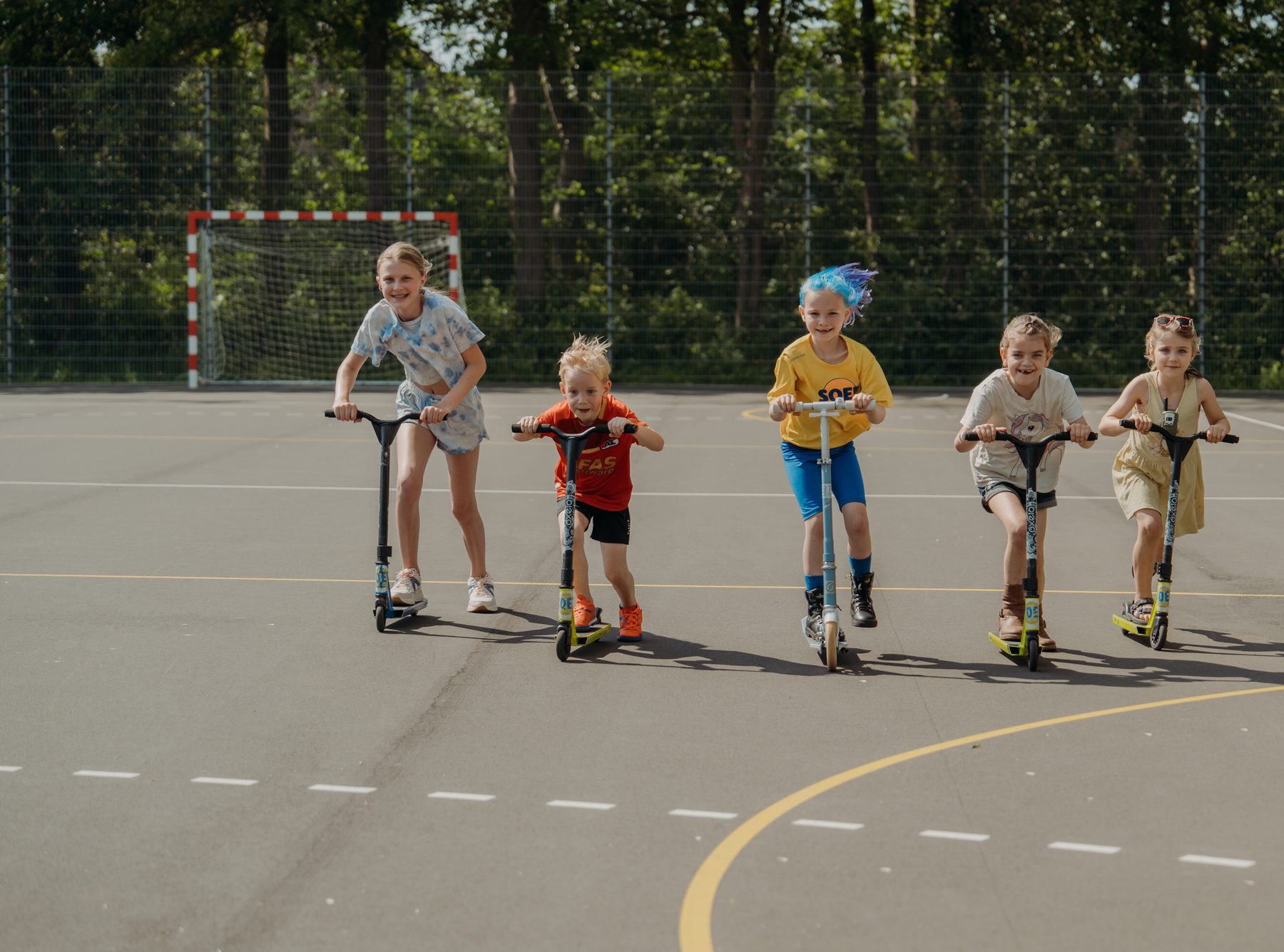 Kinderen steppen samen over het sportpark