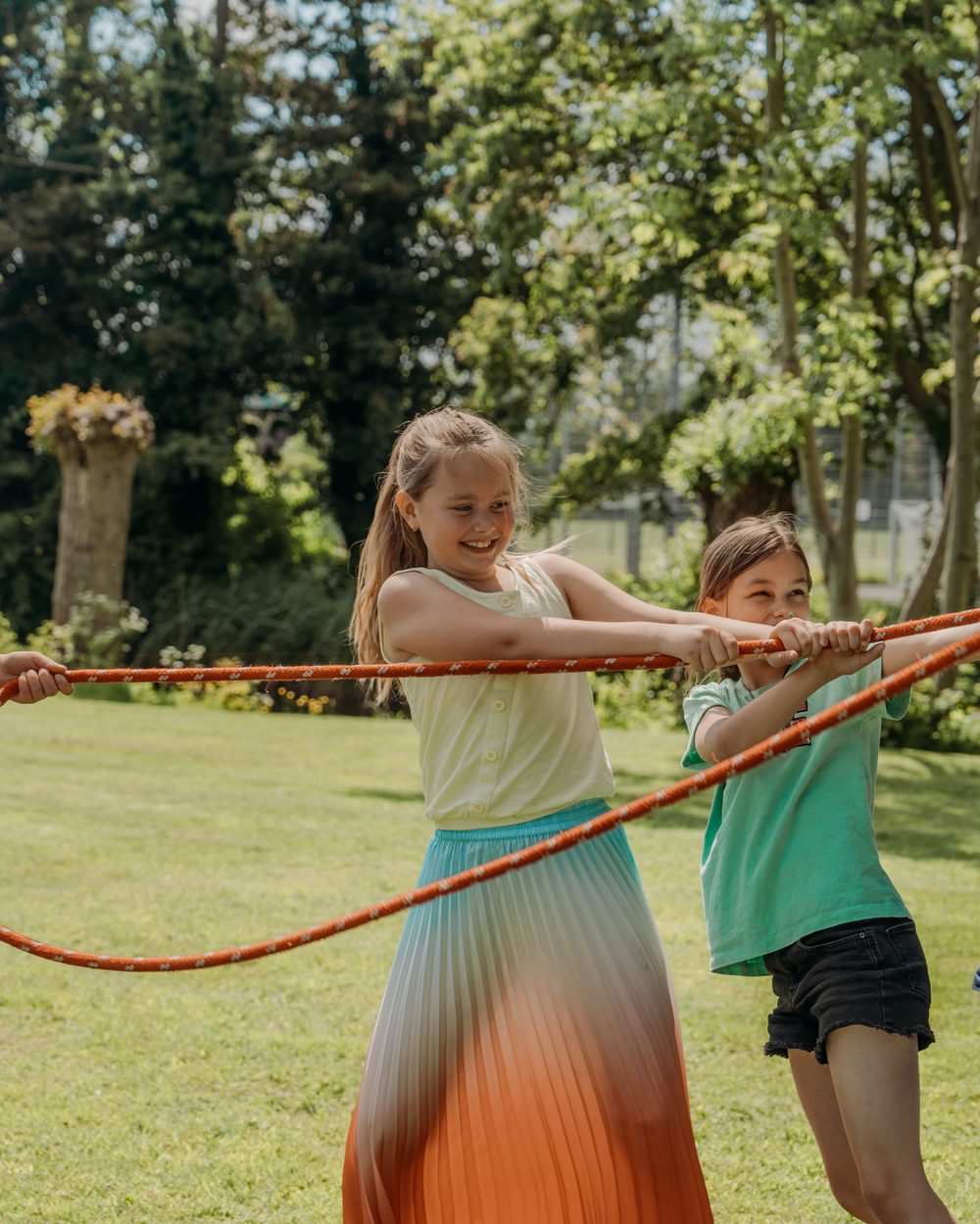 Kinderen spelen samen met een lang springtouw